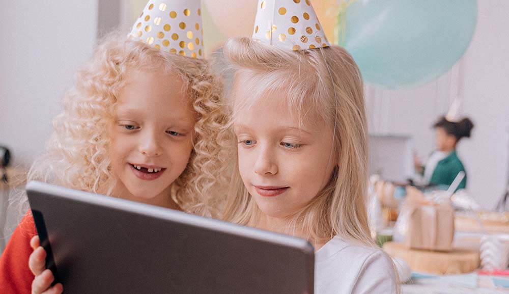 Girls looking at digital invites.